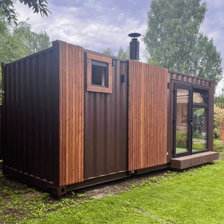 Shipping container sauna module with timber cladding strips, window and glass doors