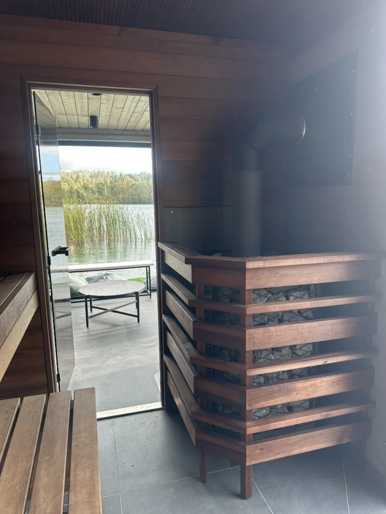 Usinsh IV sauna room with a wood burning stove in a timber guard and the door to the anteroom